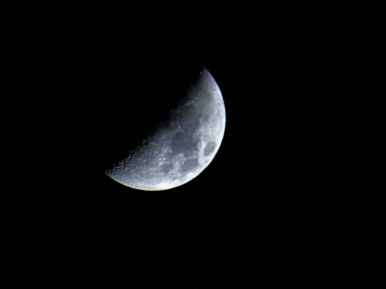 Captivating crescent moon visible against a dark night sky, showcasing lunar details.